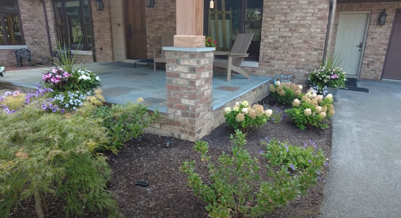 Custom bluestone patio with brick columns and outdoor seating area in Brookline, MA